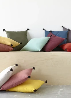 COUSSIN EN COTON UNI AVEC PETITS POMPONS ROUILLE